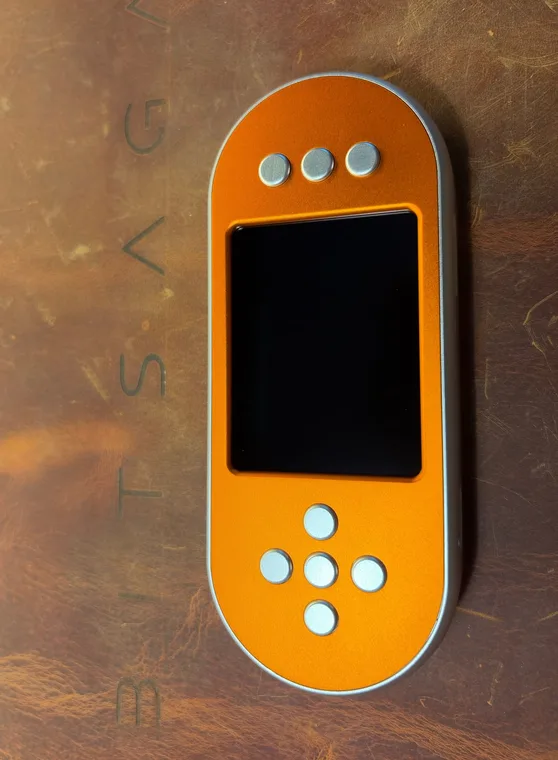 The orange SeedSigner+ Premium seen face on, silver buttons on an anodised orange front plate around the dark 2.8 inch screen