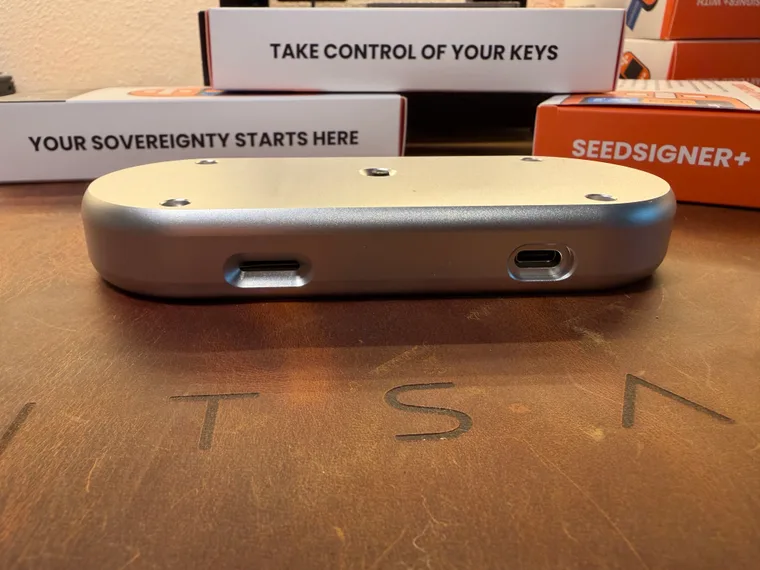 The bottom edge of the silver SeedSigner+ Premium, with the USB-C power port on the left and the microSD slot on the right